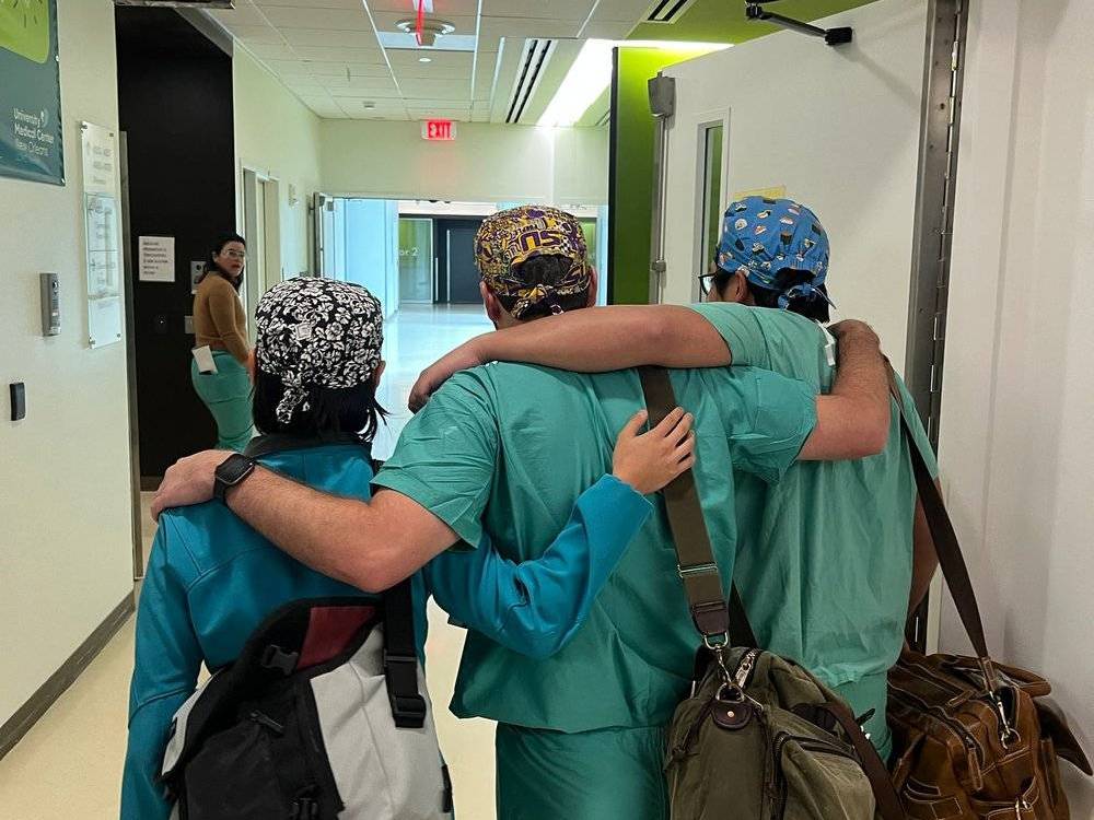three residents with their arms around each other